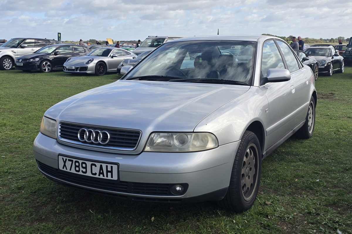 A silver first-generation (B5) Audi A4 sedan parked on grass at an outdoor car show