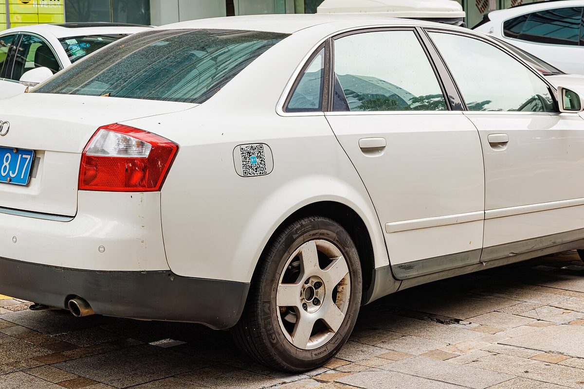 A white Audi A4 sedan of the B6 generation, seen from the rear corner in a parking area