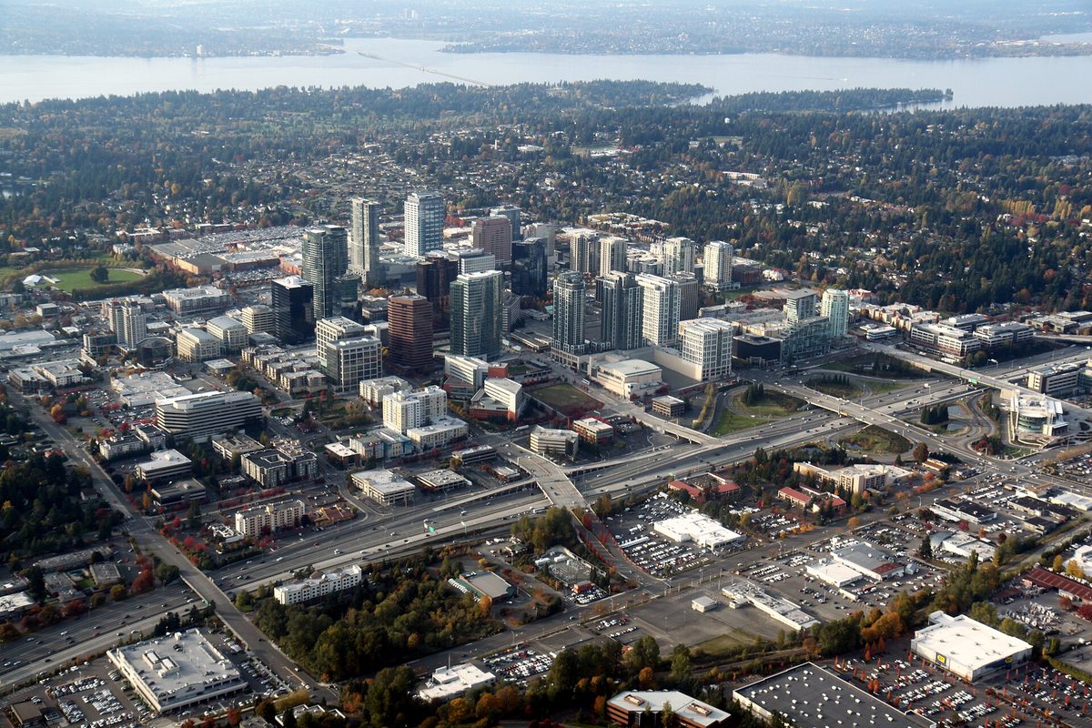 Aerial view of downtown Bellevue's towers and the I-405 freeway in autumn, with Lake Washington stretching behind