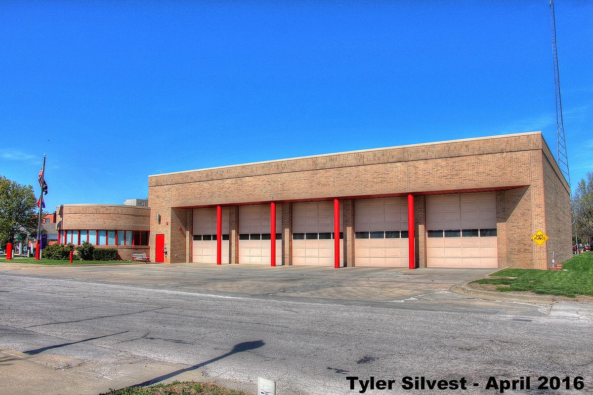 Belton Fire Department Station 1 on Main Street, a tan brick firehouse with five garage doors between red pillars under a clear blue sky