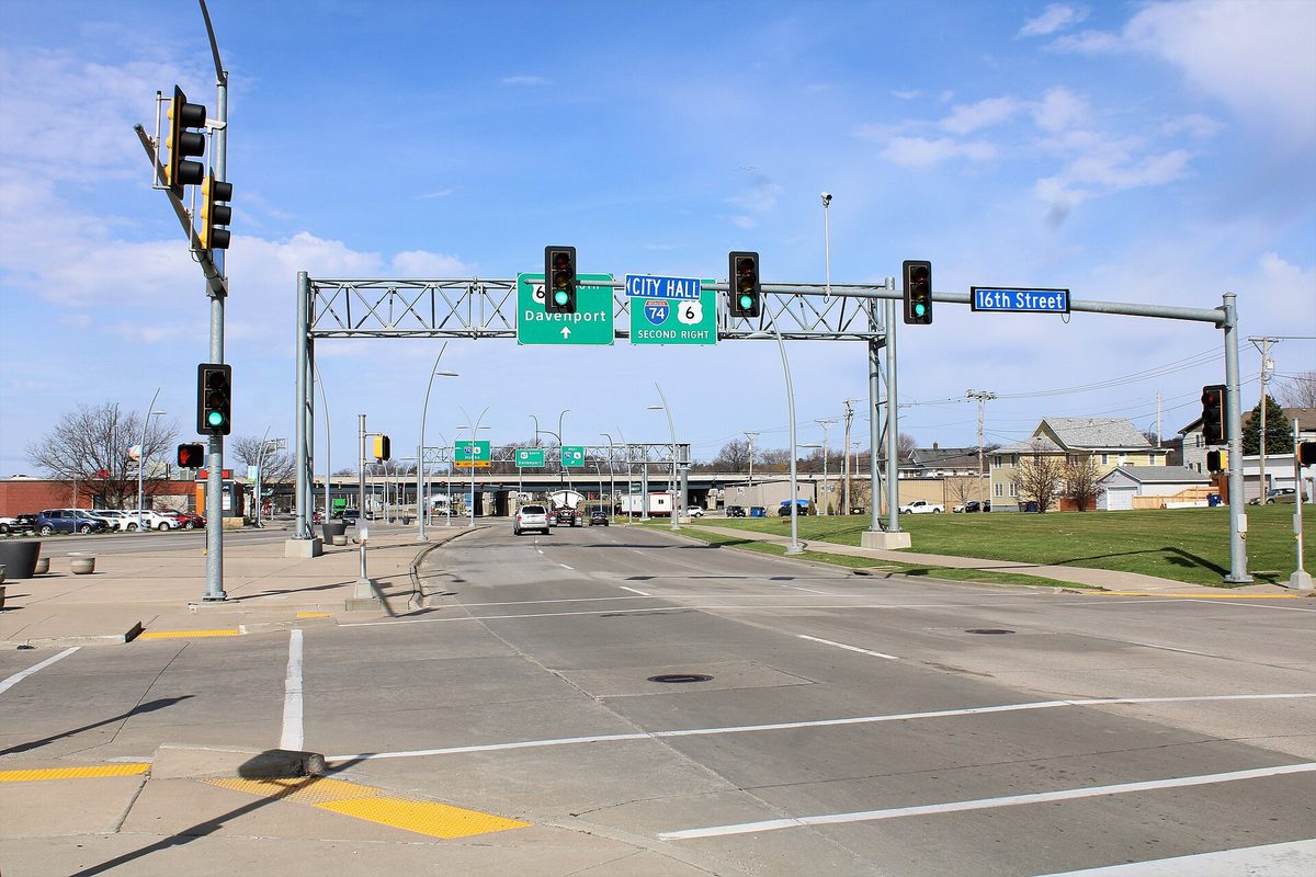 The Grant Street intersection in downtown Bettendorf, with green overhead signs pointing to Davenport and to City Hall at the I-74 interchange