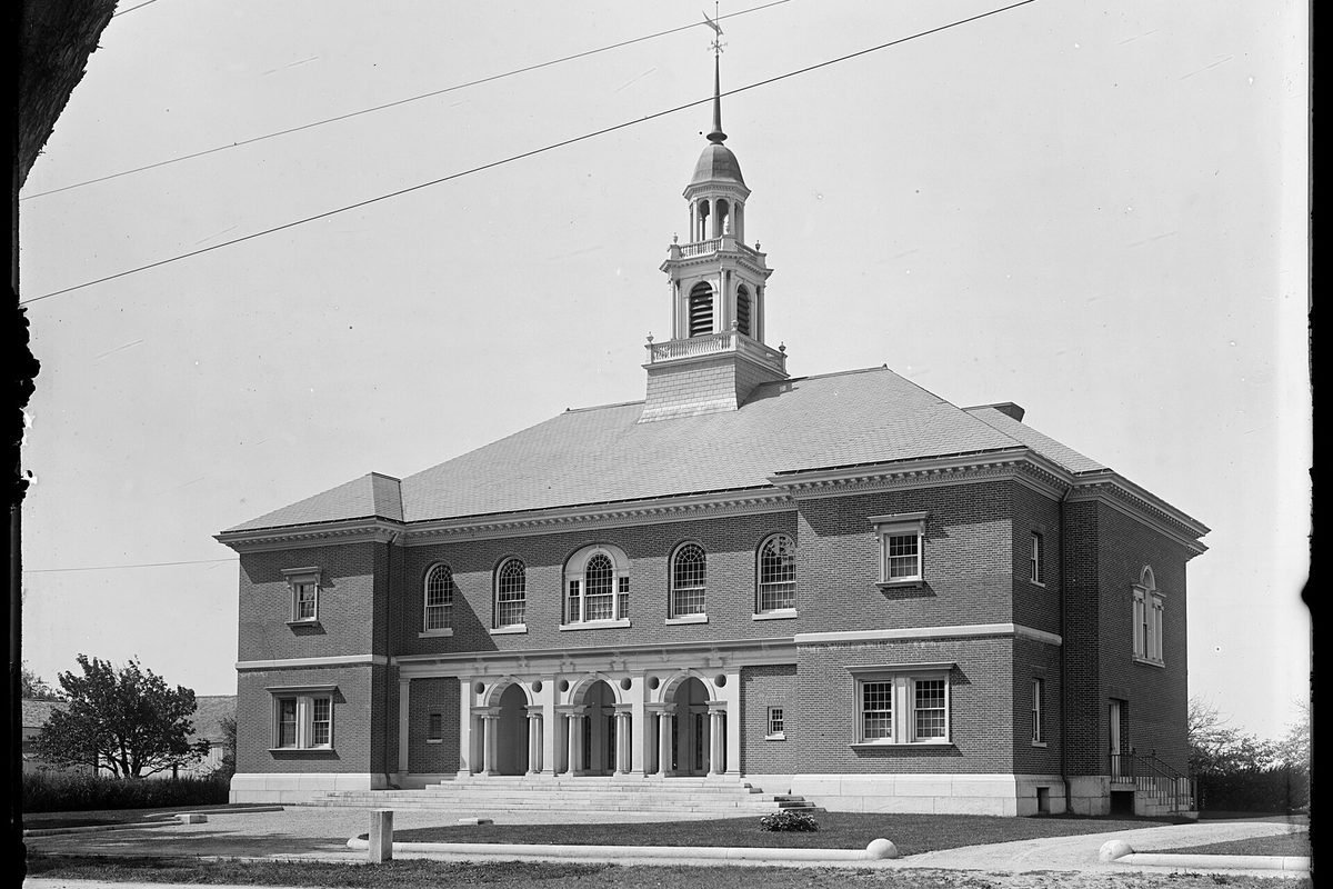 An old black-and-white photograph of Billerica Town Hall, a two-story brick building with arched windows, a columned entrance and a white cupola