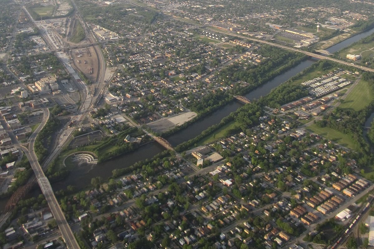 An aerial view of Blue Island with the Cal-Sag Channel curving through rows of houses, rail yards and highway bridges