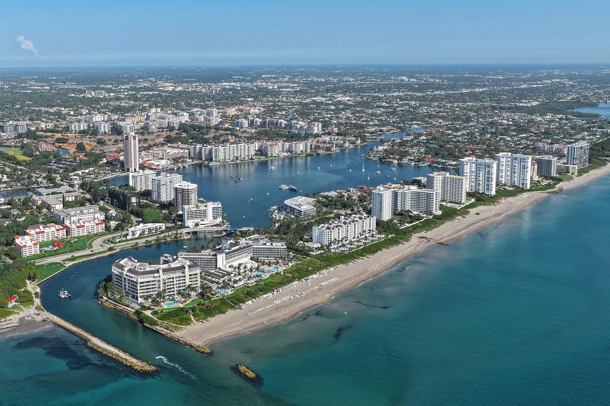 Aerial view of Boca Raton's white beachfront towers, the Boca Raton Inlet with its rock jetty, and Lake Boca Raton behind the sandy shoreline
