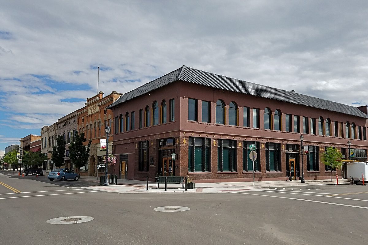 The two-story red brick Commercial Building at South Seventh Avenue and Main Street in downtown Caldwell, under a cloudy sky
