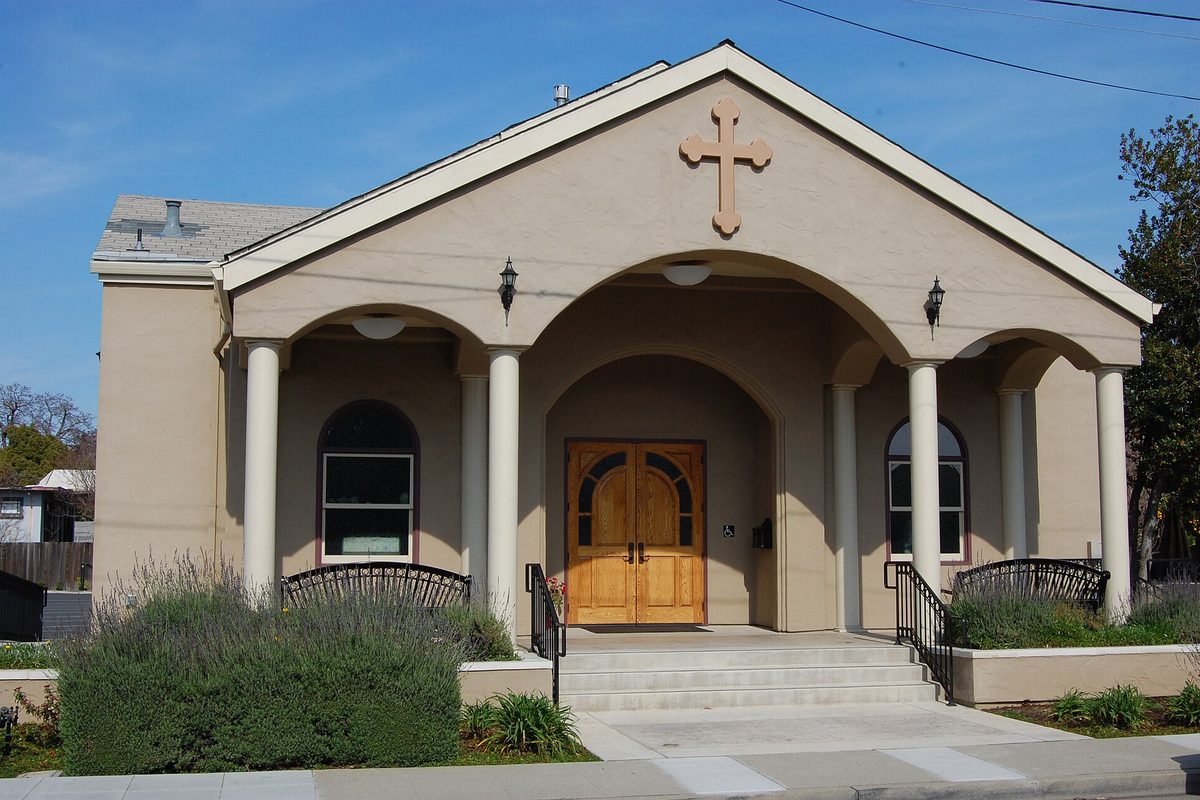Saint Stephen Antiochian Orthodox Church on East Rincon Avenue in Campbell, a tan stucco building with an arched porch, white columns, wooden doors and a cross