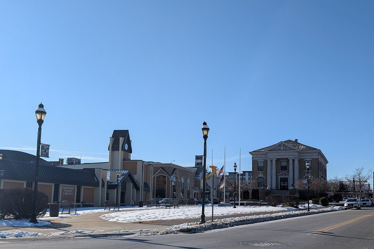 Carteret's columned Memorial Municipal Building and the public library with its clock tower, seen from Pershing Avenue with snow on the lawn