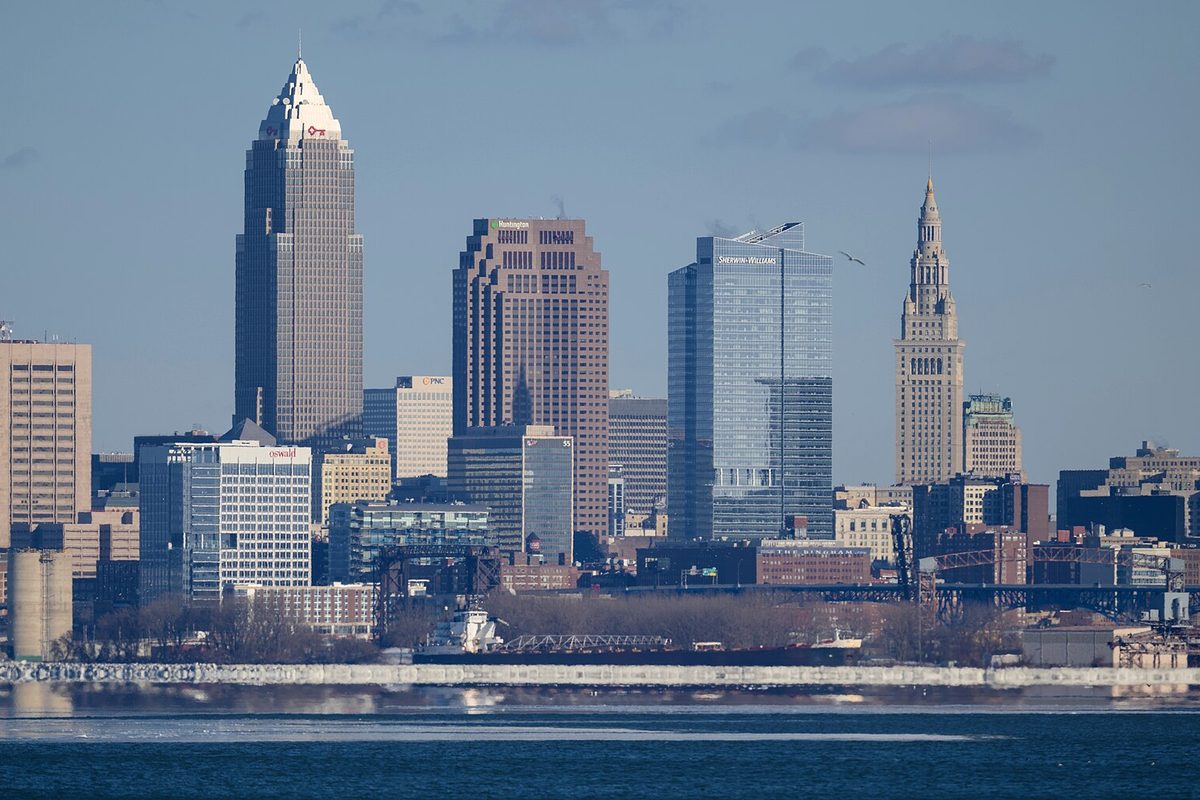Downtown Cleveland on a winter day, seen across Lake Erie: Key Tower, the Huntington and Sherwin-Williams towers and Terminal Tower rise behind a docked lake freighter