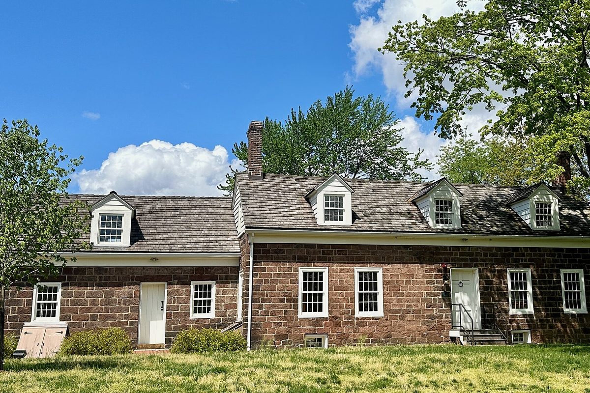 The Vanderhoef-Westervelt House in Clifton's Weasel Brook Park, a long red sandstone house with dormer windows and a shingle roof, framed by trees