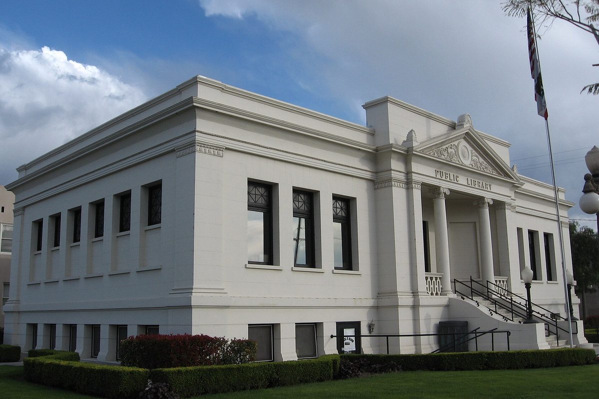 Colton's white 1908 Carnegie library, now the Colton Area Museum, with columns, a Public Library inscription and a flag out front