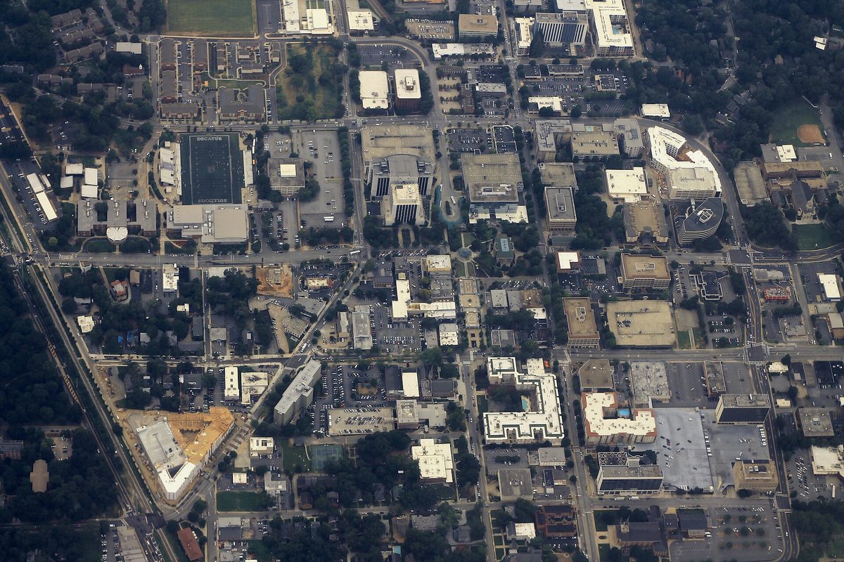An aerial view of downtown Decatur, a grid of streets, rooftops, parking lots and tree cover seen from above