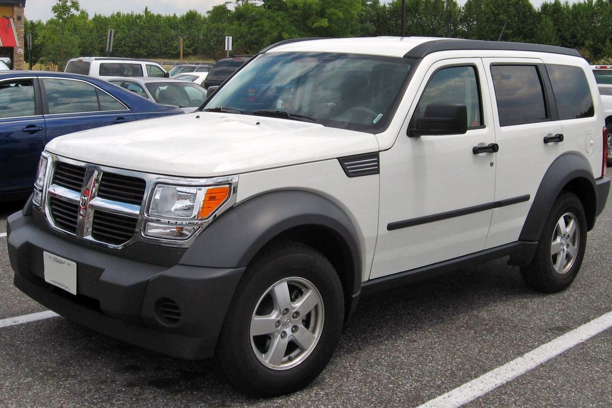 A white 2007 Dodge Nitro SUV with gray bumpers and fender flares, parked in a lot