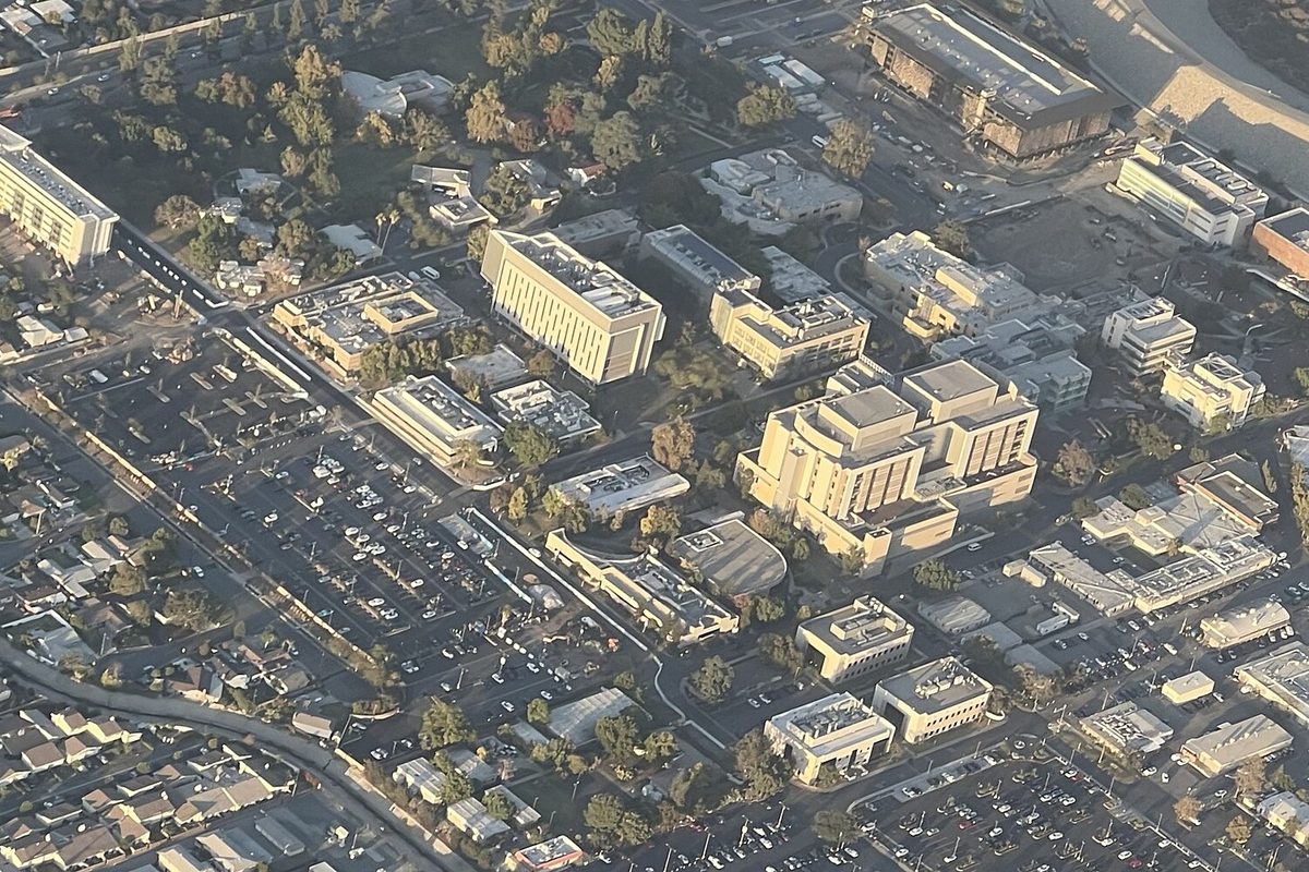 An aerial view of the City of Hope campus in Duarte, with tan medical buildings, tree-lined lanes and large parking lots