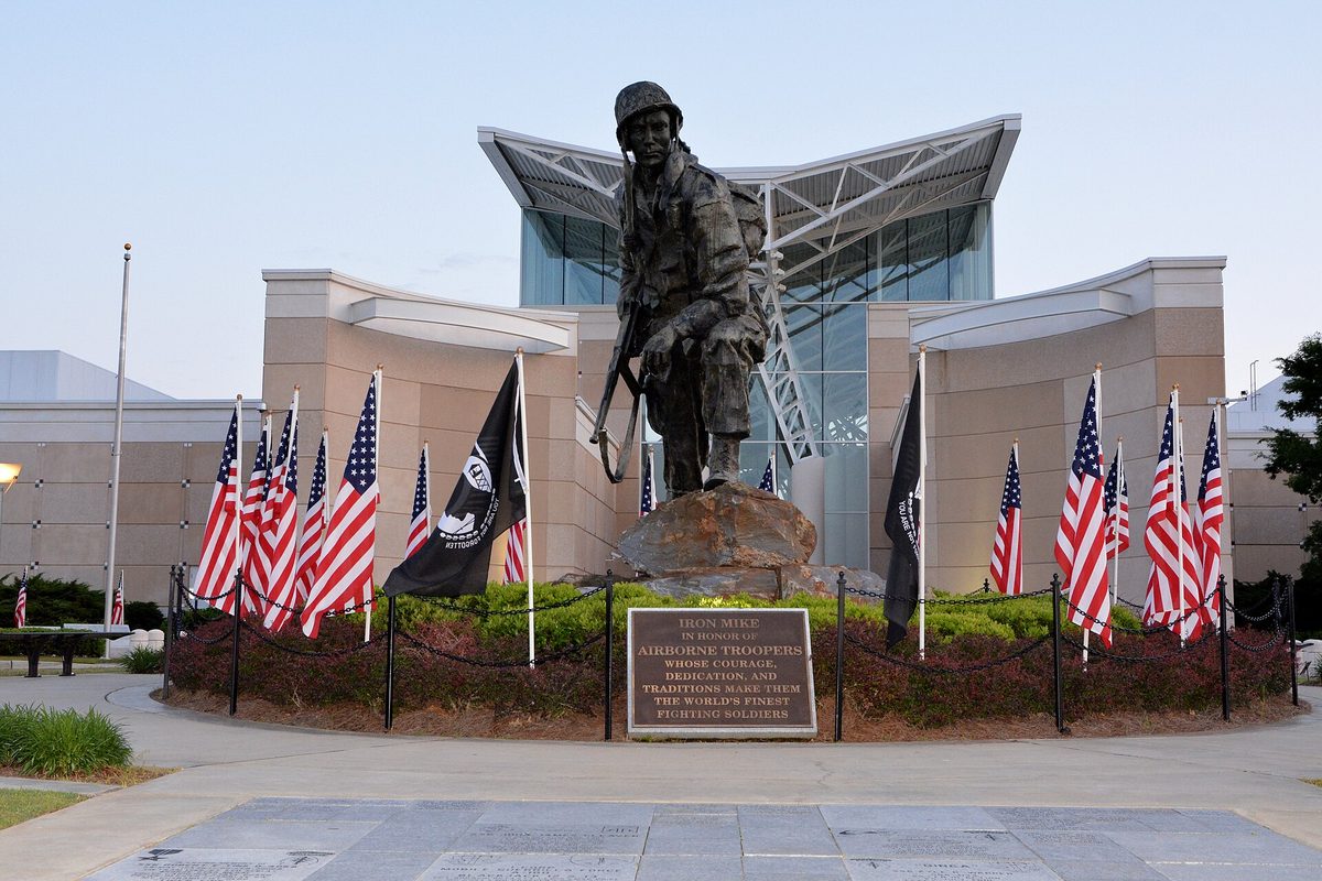 The bronze Iron Mike paratrooper statue ringed by American and POW-MIA flags in front of the Airborne and Special Operations Museum in Fayetteville