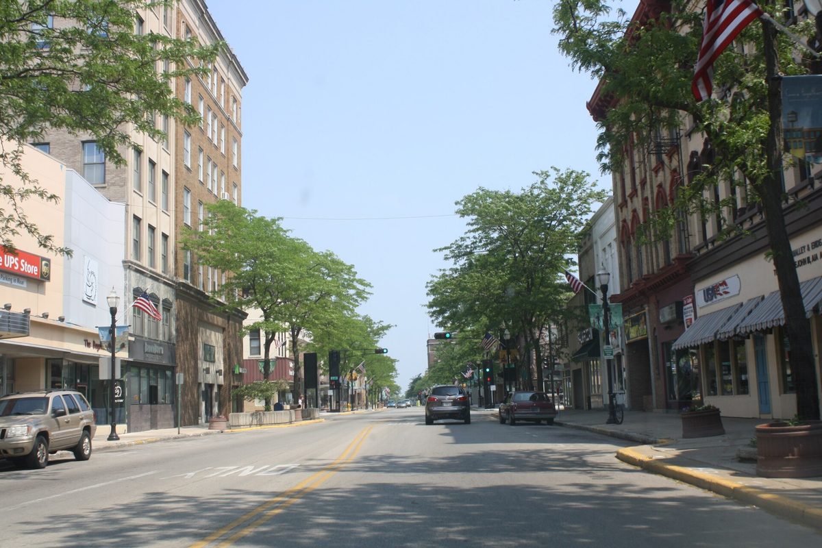 Main Street in Fond du Lac's South Main Street Historic District, lined with older brick buildings, flags and leafy trees