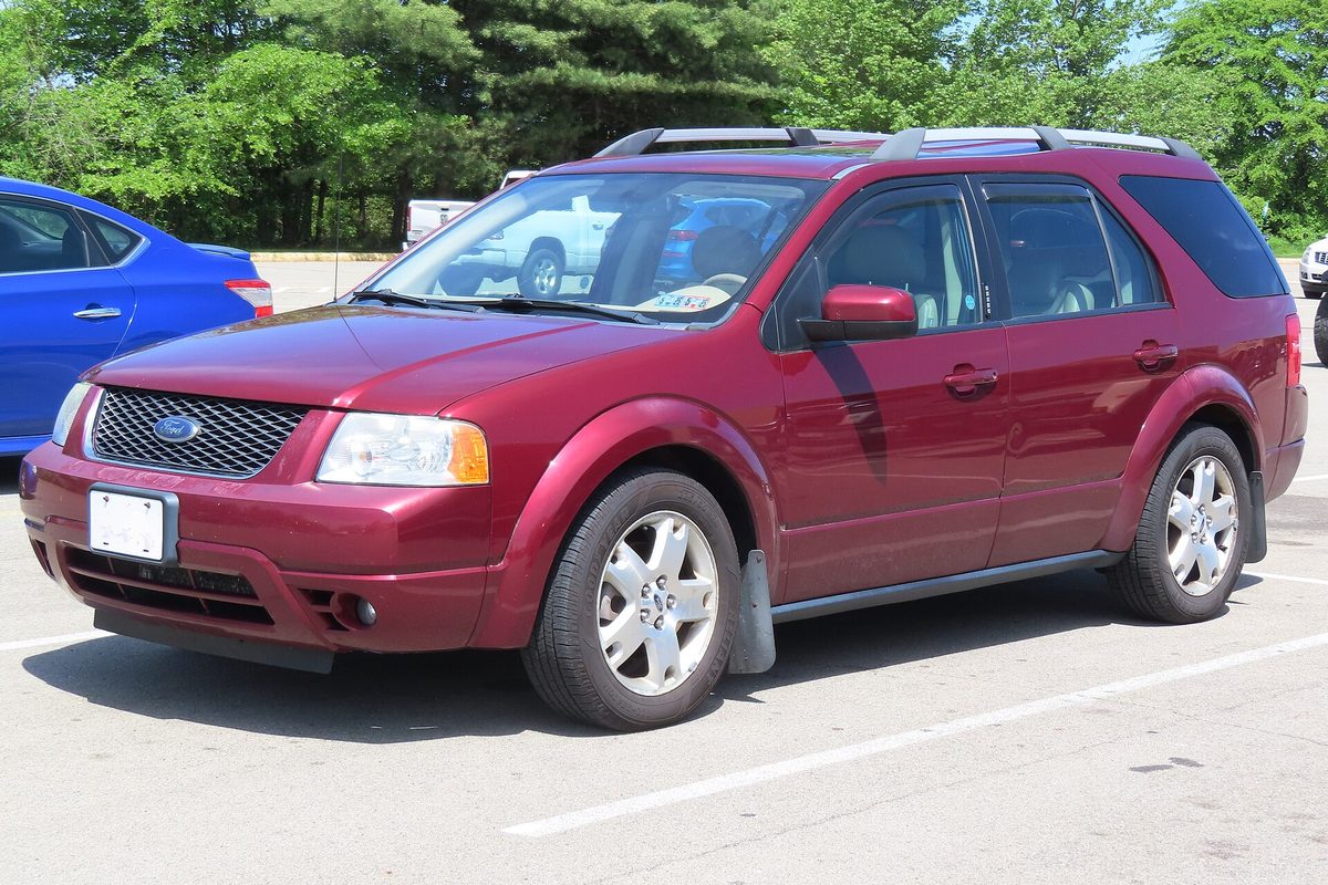 A maroon 2006 Ford Freestyle Limited crossover in a sunny parking lot, a blue car parked beside it