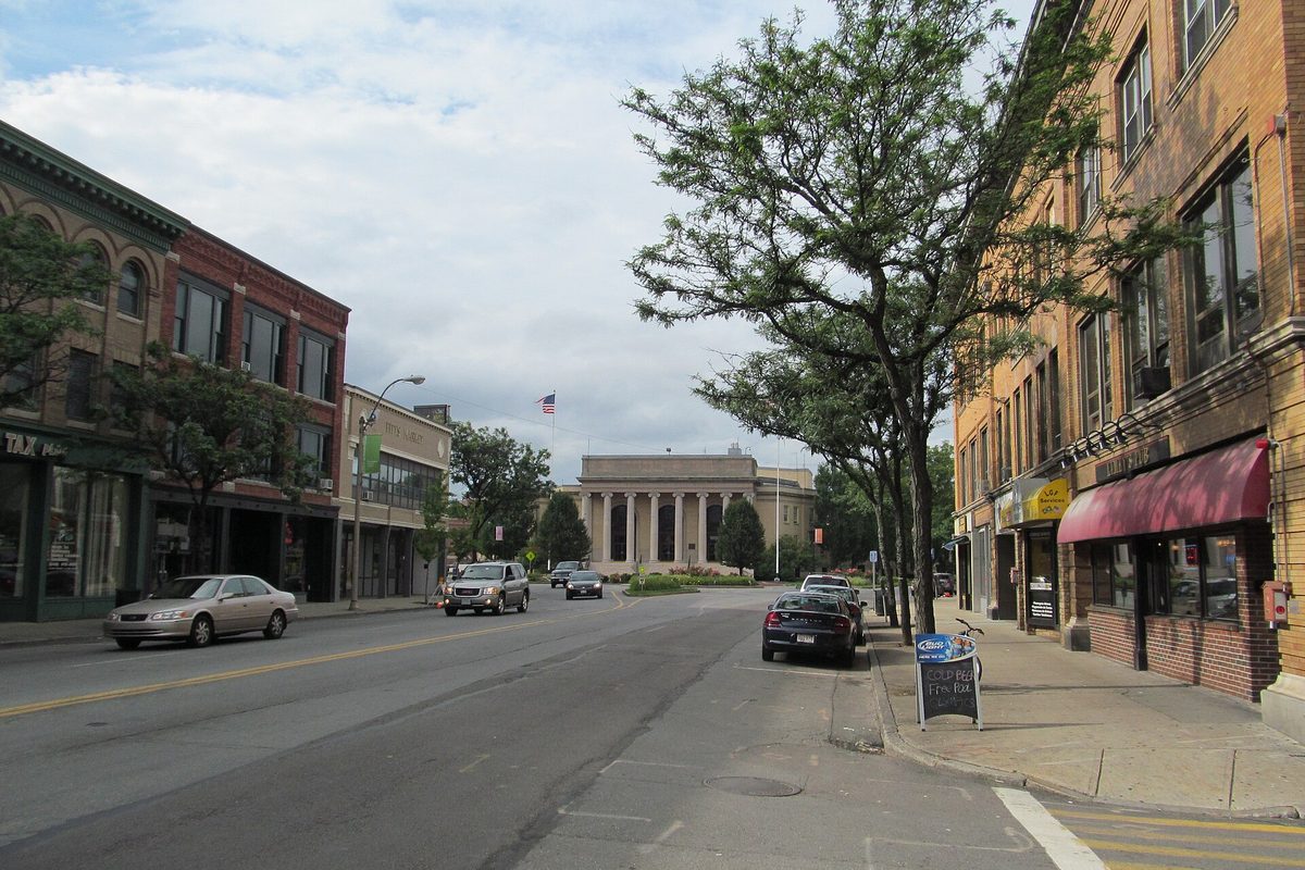 Concord Square in downtown Framingham, brick storefronts on both sides of the street and a columned civic building at the far end
