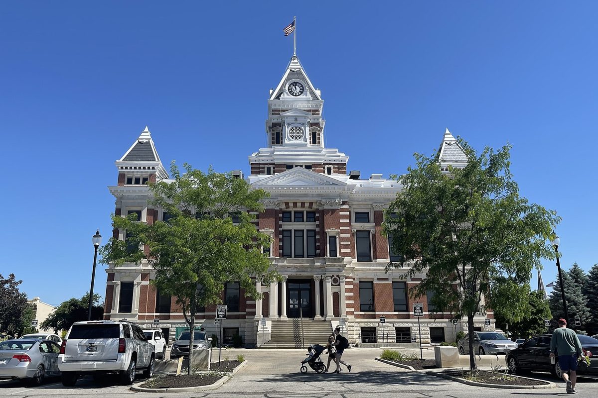 The red brick and white stone Johnson County Courthouse in Franklin, with its clock tower and trees out front under a clear blue sky