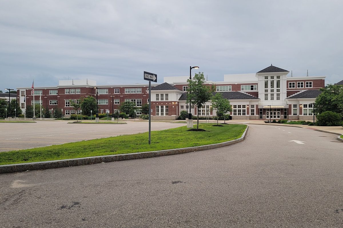 Franklin High School, a long red-brick building with white trim and a cupola, behind a curved drive and a large empty parking lot