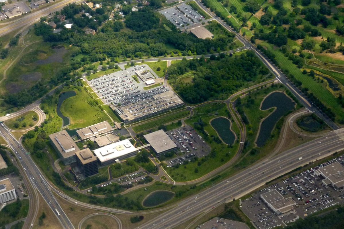 Aerial view of the General Mills headquarters campus in Golden Valley, with low office buildings, large parking lots and small ponds beside a freeway interchange