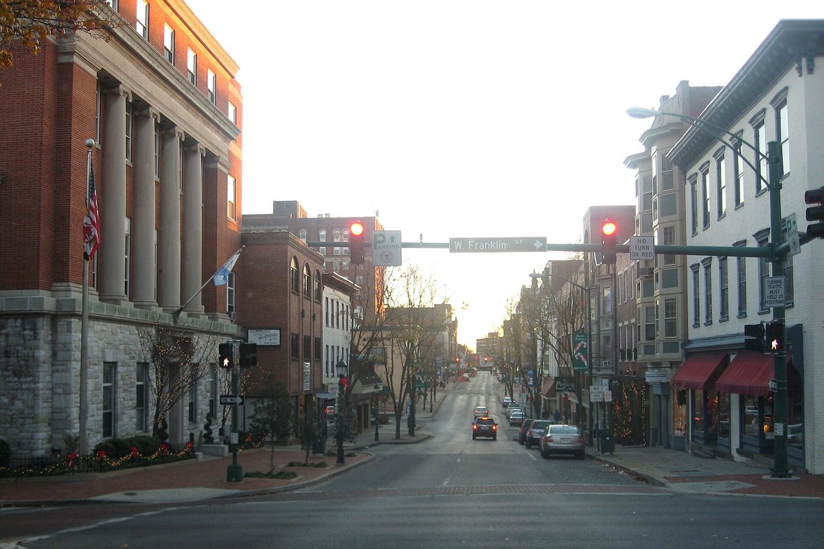 Potomac Street in downtown Hagerstown at dusk, with a columned brick building on the left, red traffic lights and a W. Franklin St street sign