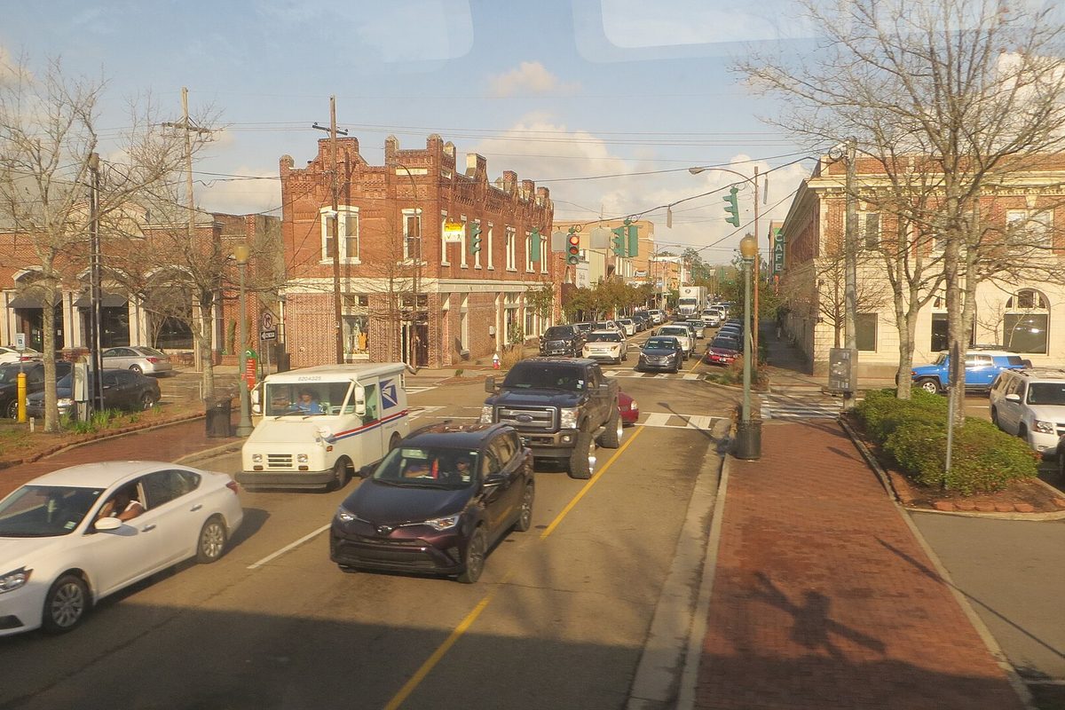 Traffic on a downtown Hammond street lined with red brick storefronts and young trees