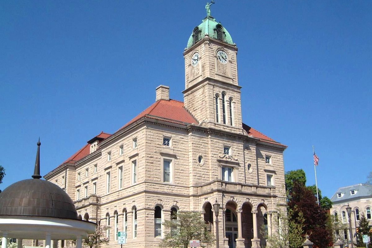 The stone Rockingham County Courthouse with its green-domed clock tower in Court Square, Harrisonburg, under a clear blue sky