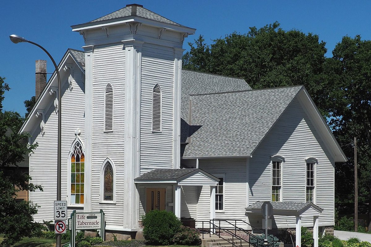 The white wooden former Hastings Methodist Episcopal Church, now Life Tabernacle, on Vermillion Street, with a square bell tower and stained glass windows