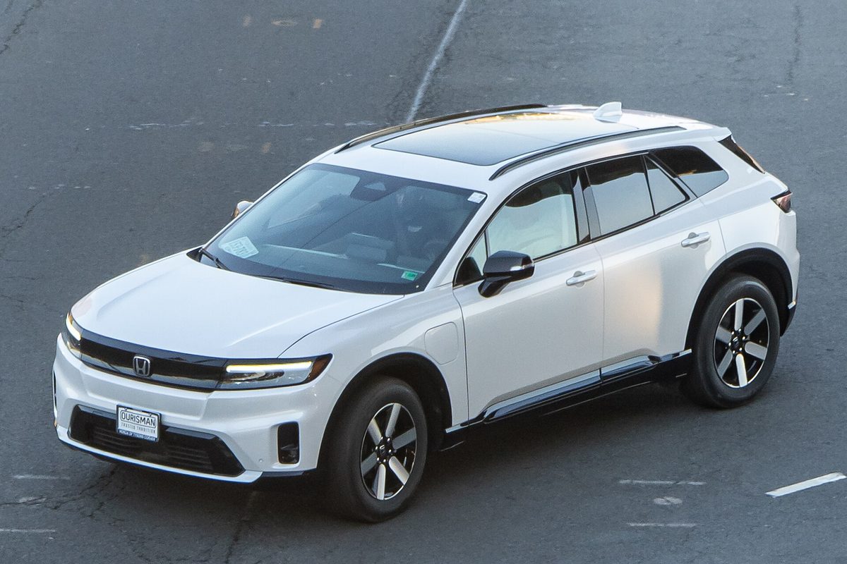 A white Honda Prologue electric SUV seen from above on a parking lot, with a dealer plate frame on the front