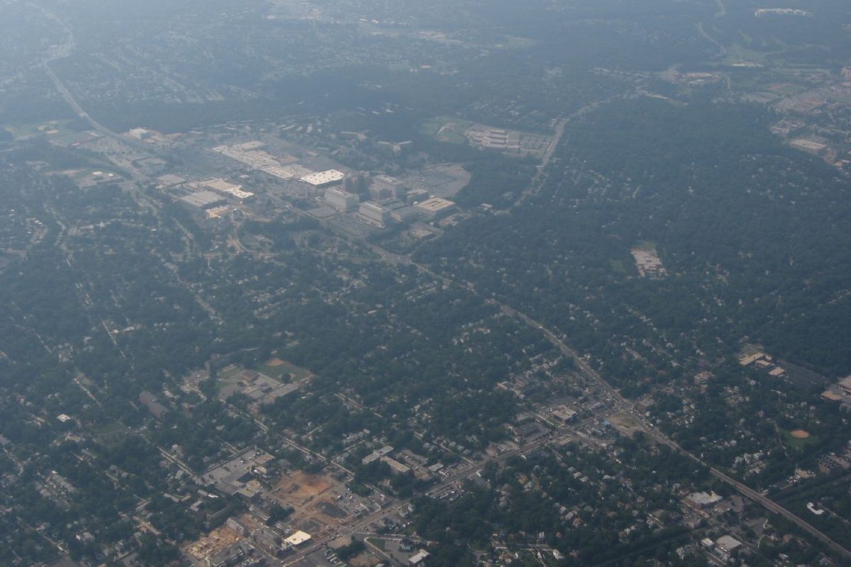 Hazy aerial view over Hyattsville, with the Prince George's Plaza shopping area among tree-covered neighborhoods and roads