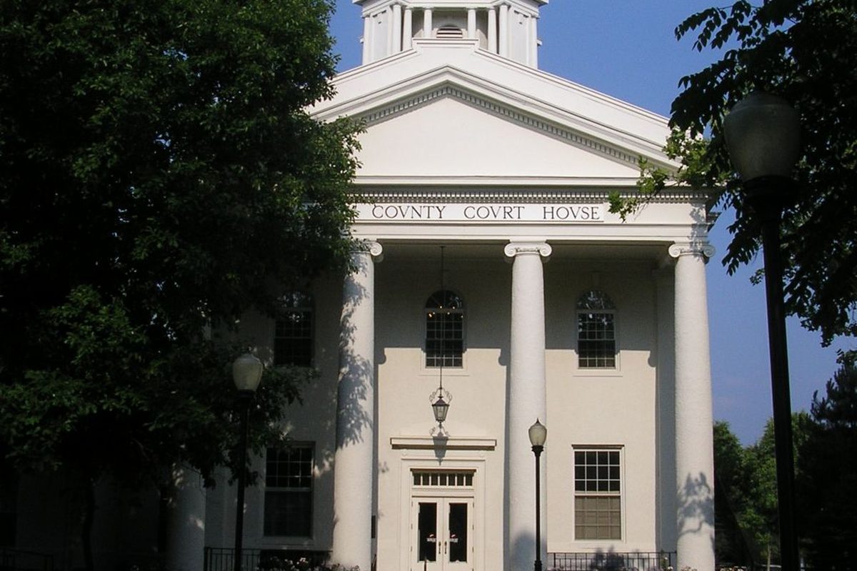 The white-columned Kenton County Courthouse in Independence, with COUNTY COURT HOUSE carved above the entrance and trees on both sides