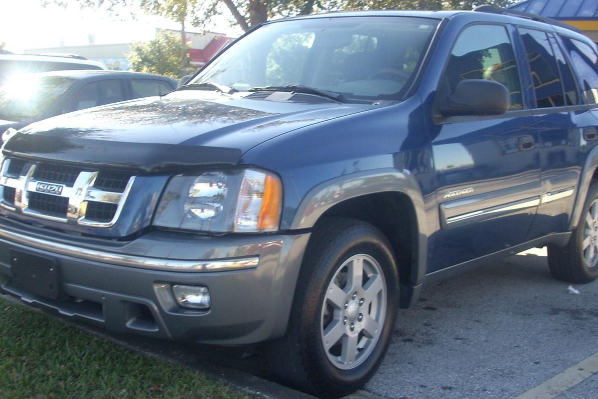 A dark blue 2005 Isuzu Ascender five-passenger SUV with gray lower trim and a bug deflector on the hood, parked beside a lot