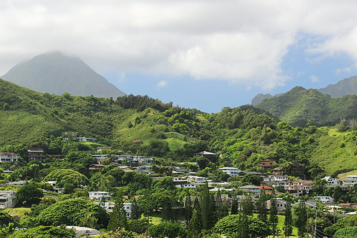 Houses scattered over the green slopes of Kokokahi Ridge in Kaneohe, with a cloud-capped peak behind them