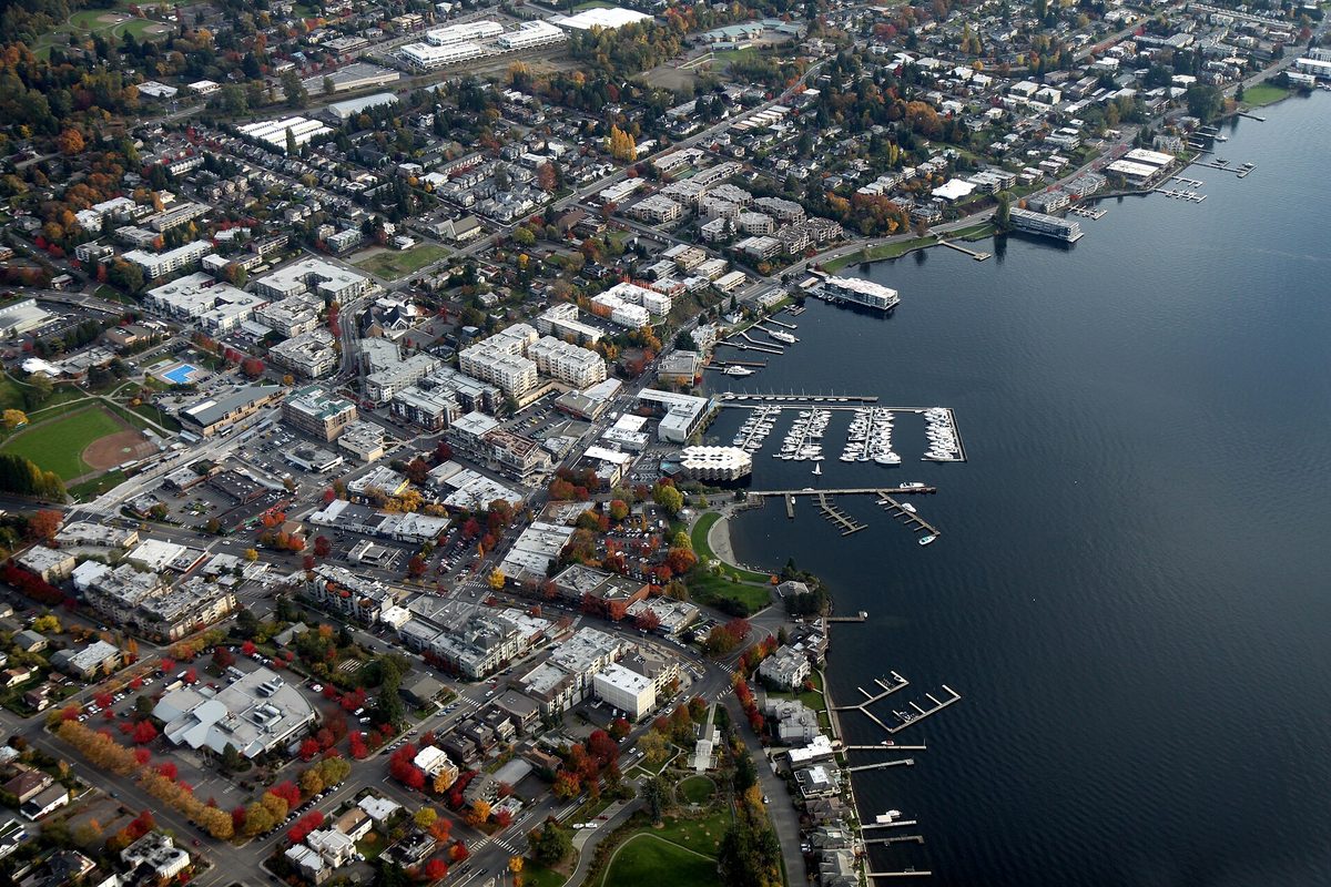 Aerial view of downtown Kirkland in autumn, with marinas and docks along the Lake Washington shore and red and gold trees among the buildings