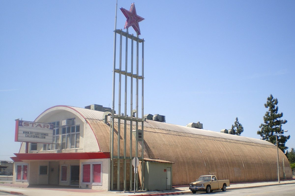 The Star Theater in La Puente, a curved Quonset-style building with a tall star sign, with an old pickup truck parked outside