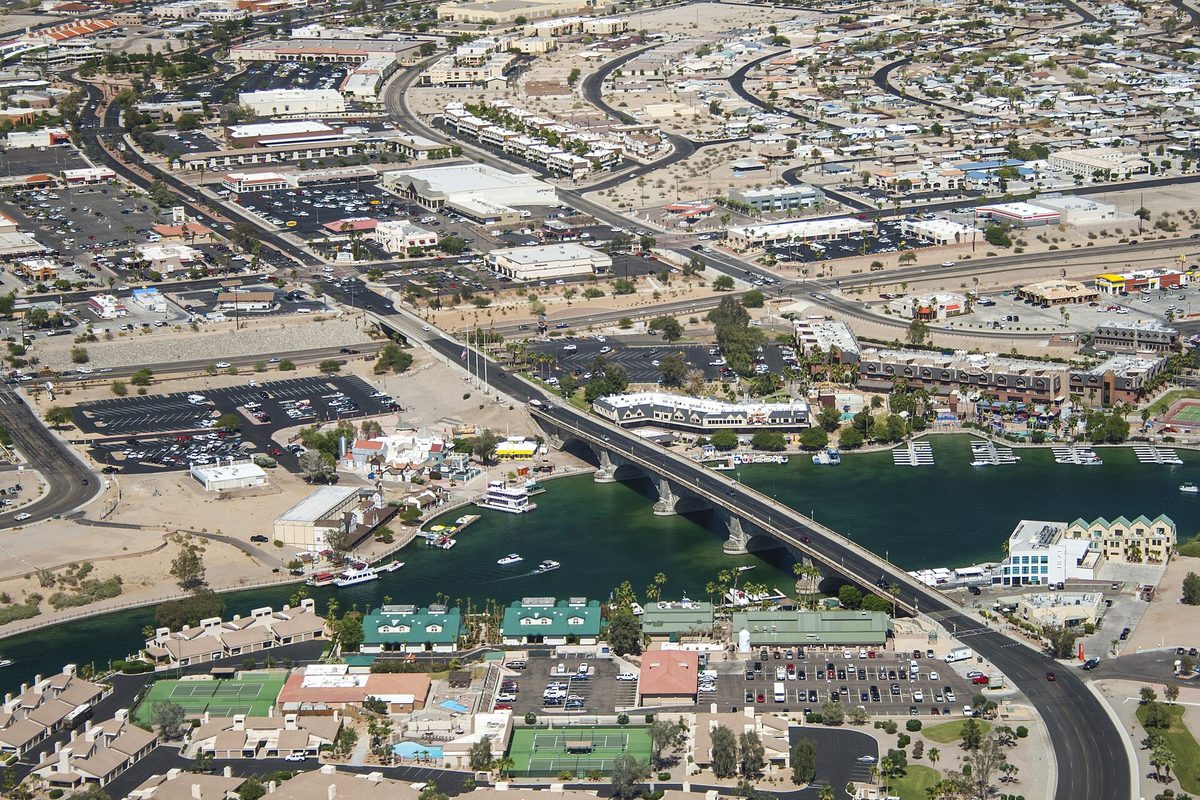 Aerial view of London Bridge crossing the channel in Lake Havasu City, with boats on the water and parking lots behind