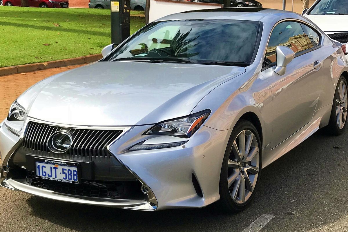 A silver 2017 Lexus RC 350 coupe with a spindle grille, parked at a curb beside a strip of grass