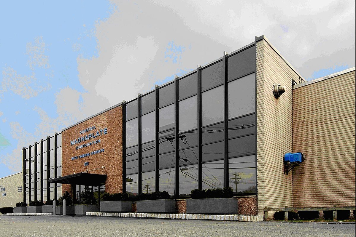 The General Magnaplate Corporation headquarters in Linden, a low building with a tall black glass front set into brick walls