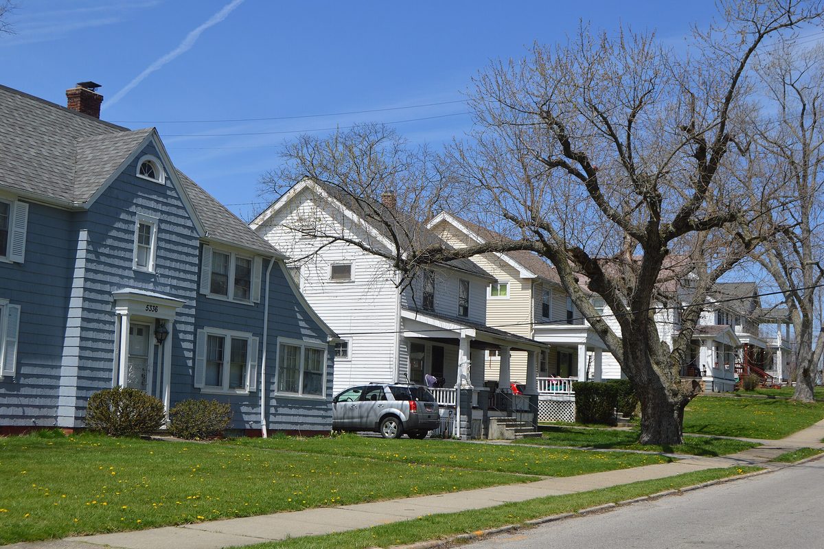 Two-story frame houses with front porches and lawns along Vine Street in Maple Heights, a silver SUV in one driveway and bare trees in early spring