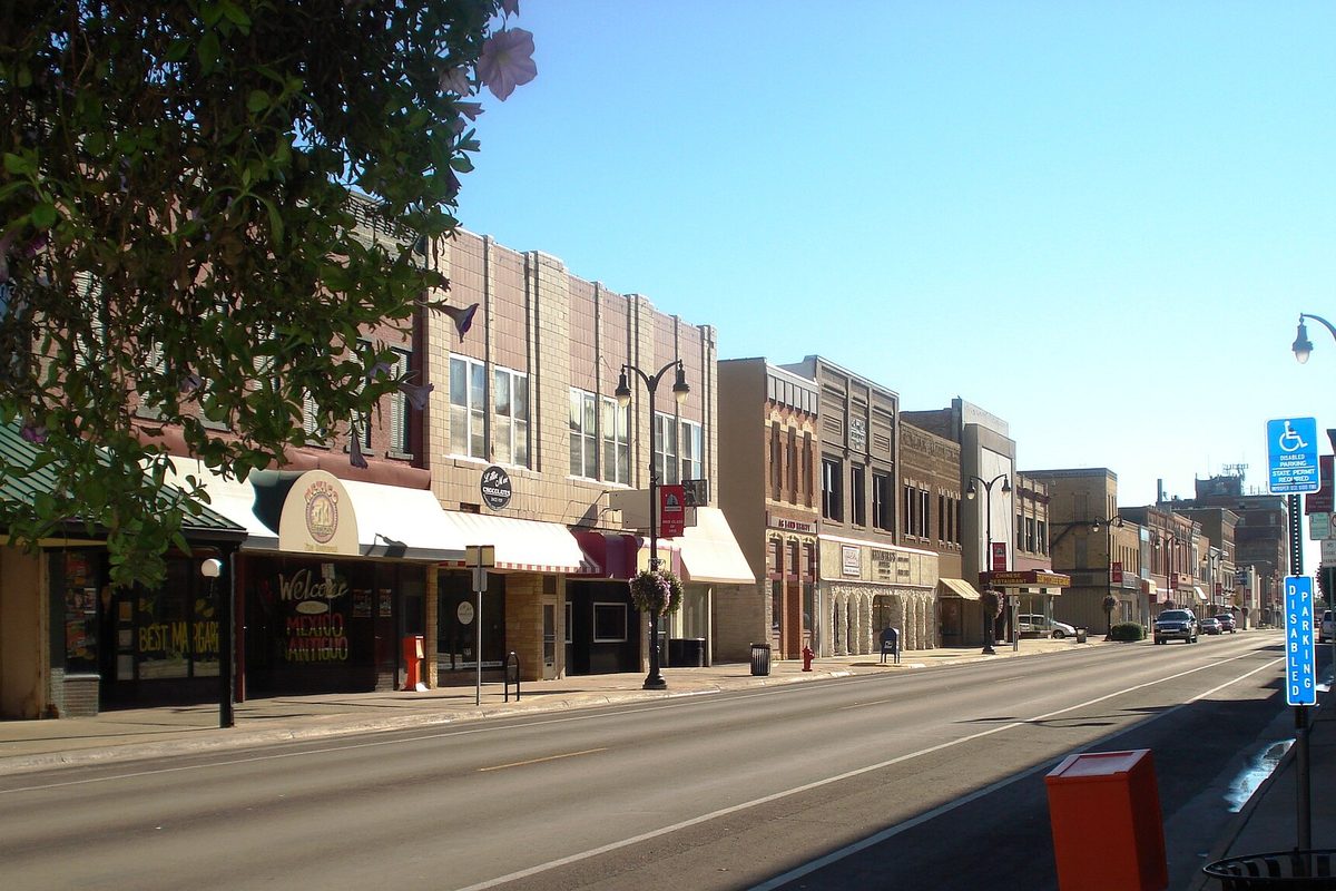 Two- and three-story brick storefronts with awnings along historic Main Street in Marshalltown on a clear morning