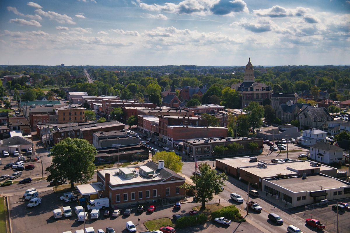 Aerial view over Uptown Marysville from the downtown grain silo: brick storefront blocks, parking lots and a domed clock tower rising above the trees