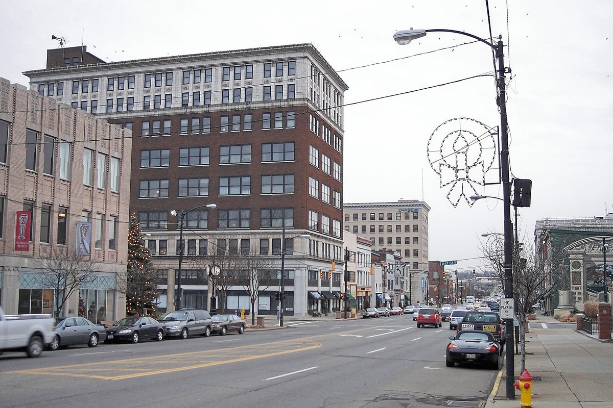 Lincoln Way in downtown Massillon on a grey winter day, with a tall brick office building, a decorated Christmas tree and parked cars along the curb
