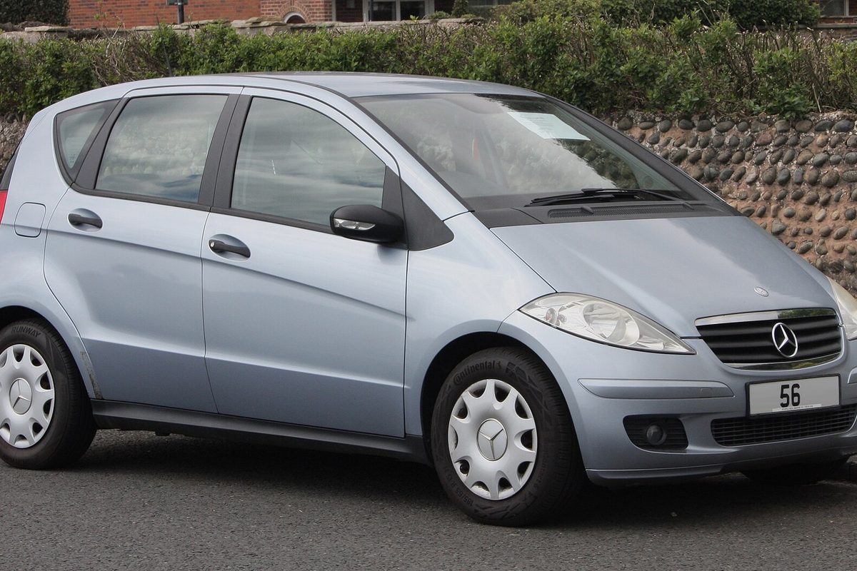 A light blue 2006 Mercedes-Benz A-Class A150 five-door hatchback parked in front of a flint wall