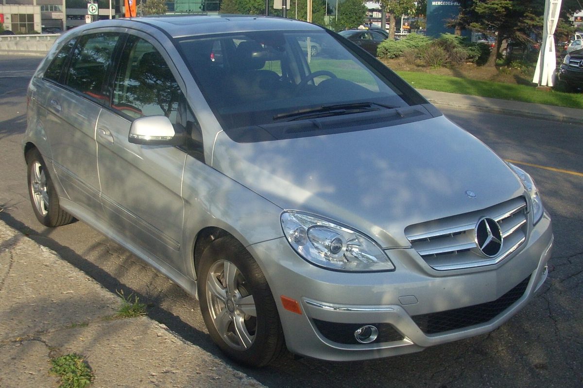 A silver Mercedes-Benz B-Class hatchback parked at the edge of a road, seen from the front
