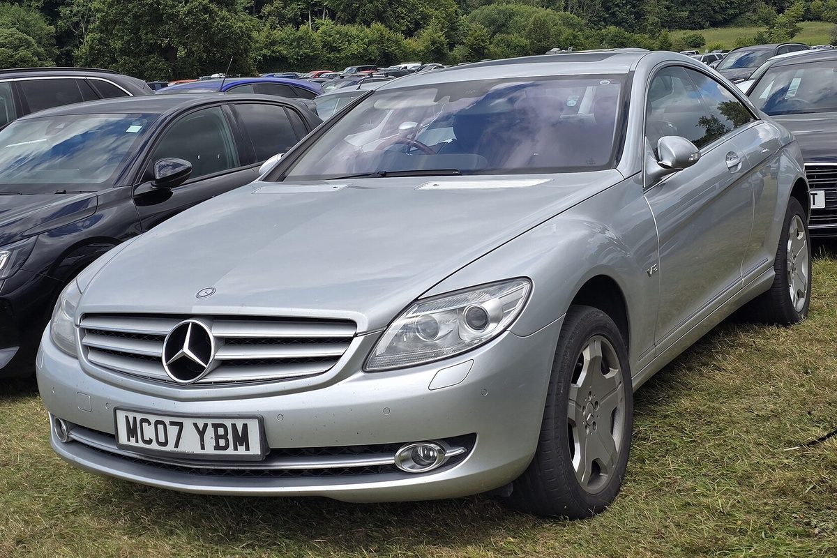 A silver 2007 Mercedes-Benz CL 600 coupe parked on grass among other cars