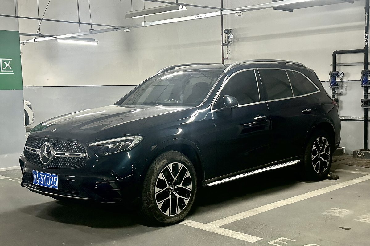A dark blue Mercedes-Benz GLC SUV parked between painted lines in an underground parking garage