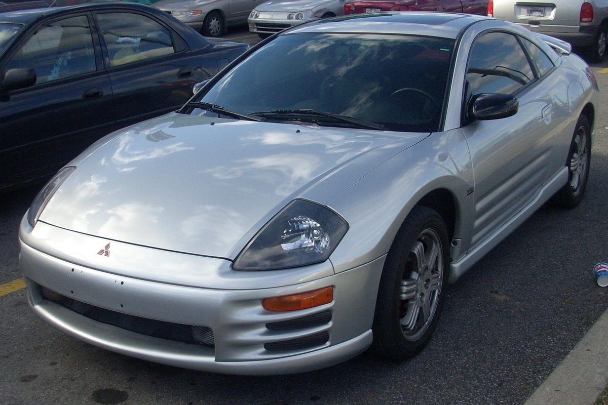 A silver 2000-2002 Mitsubishi Eclipse coupe parked in a lot, seen from the front left
