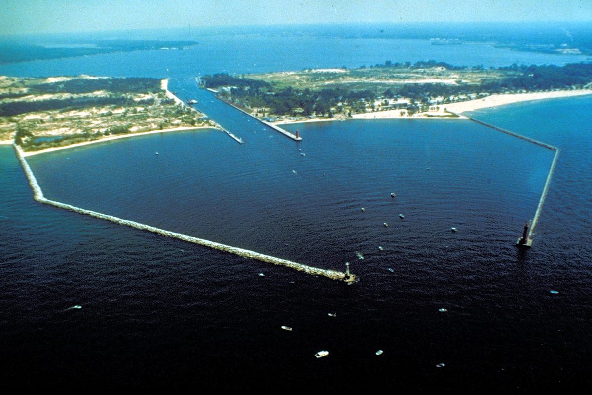 Aerial view of the stone breakwaters at Muskegon's harbor entrance on Lake Michigan, with the channel leading inland to Muskegon Lake
