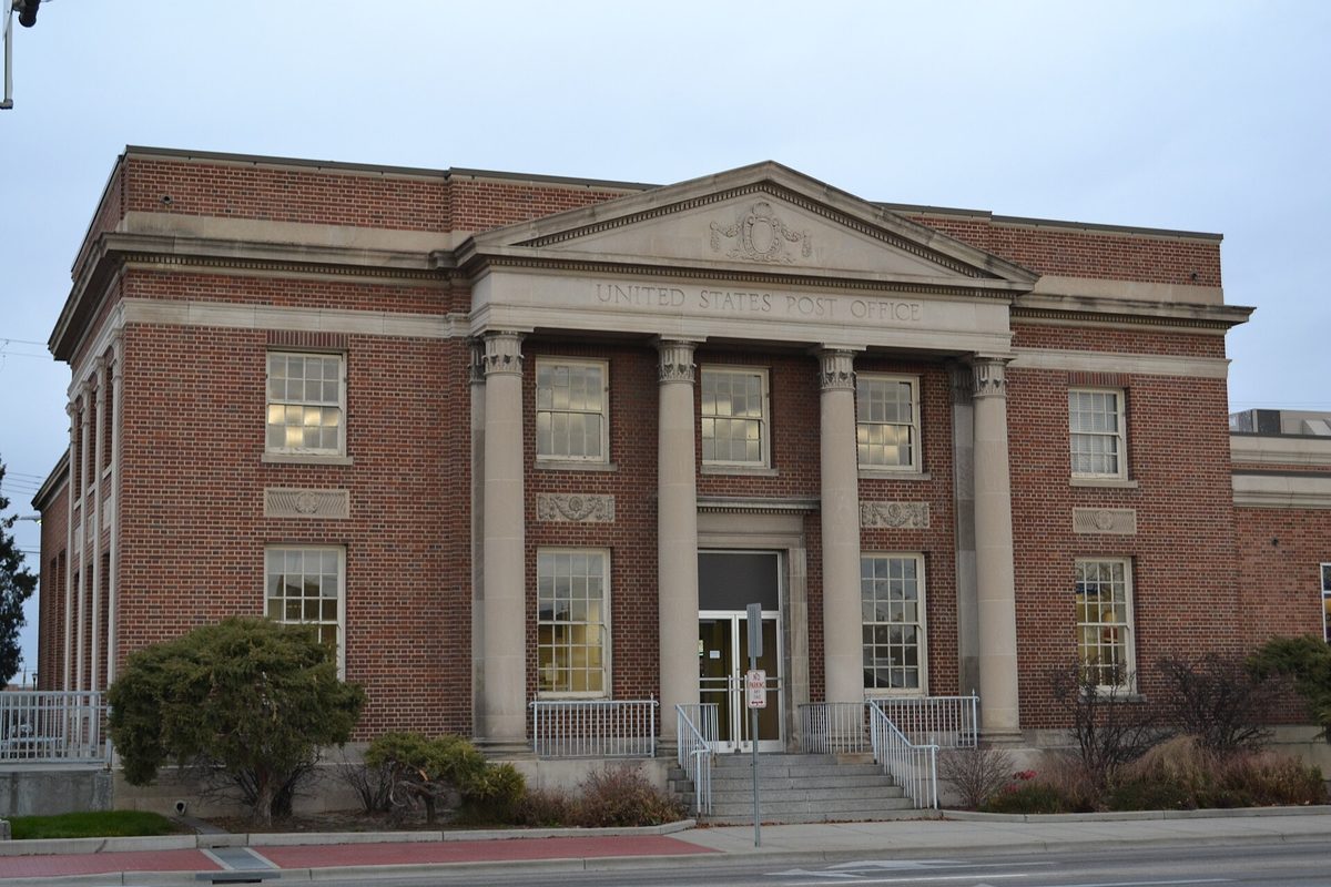 The historic red brick and stone United States Post Office in Nampa, with tall columns framing its entrance and steps
