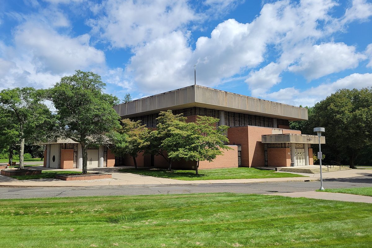 Saint Mary Church in Newington, a flat-roofed concrete and brick building set behind a wide green lawn and shade trees